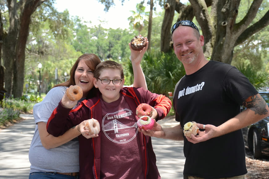 Customers holding Damn Good doughnuts outside at a market
