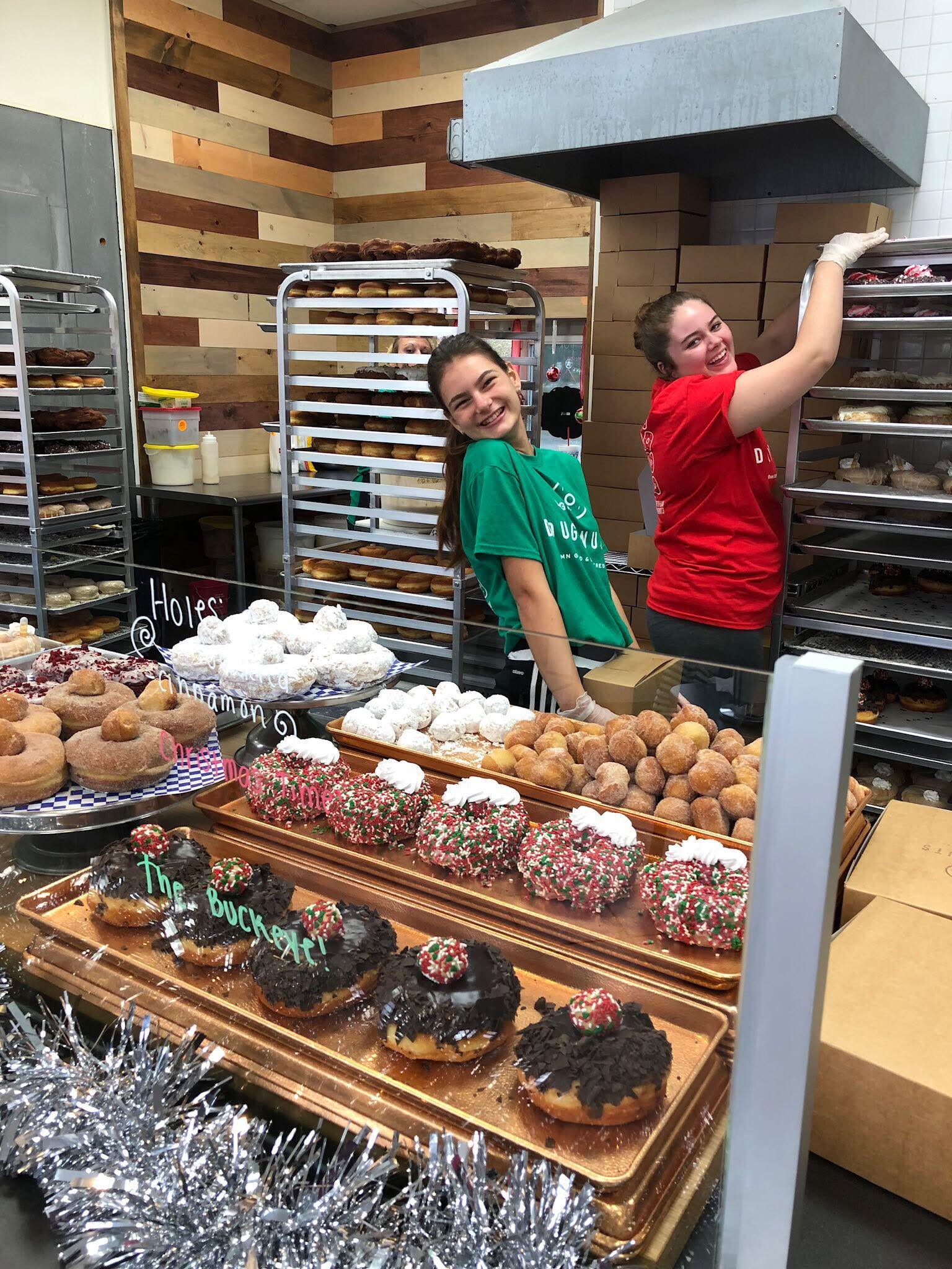 Racks of glazed doughnuts cooling in the Damn Good kitchen
